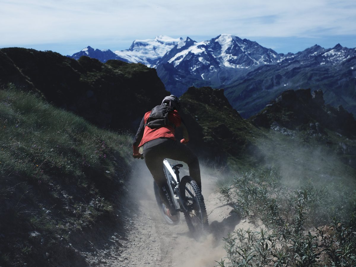 Riding a dusty alpine trail in Verbier, Grand Combin behind